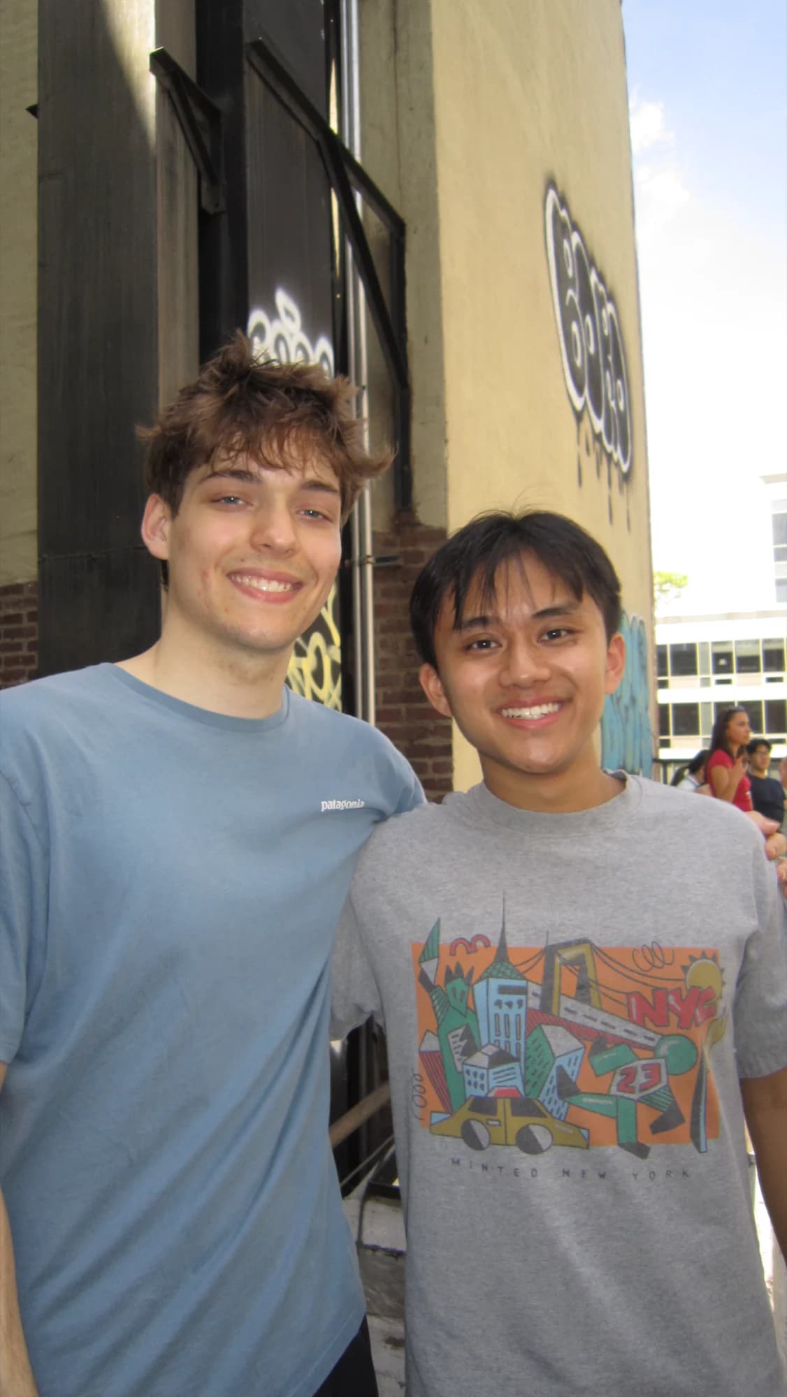 Two members posing together on a street corner