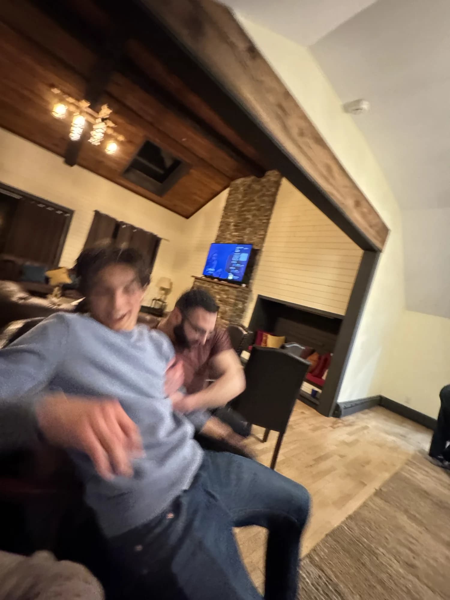 Two members tussling in a lodge living room, the shot blurred