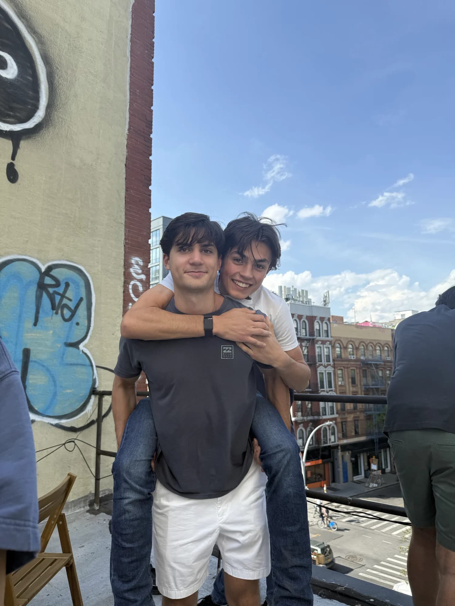 One member giving another a piggyback on a rooftop