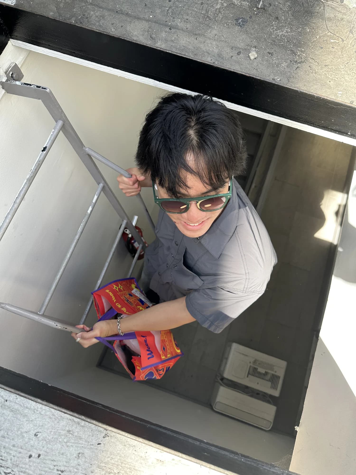 A member looking up a stairwell, carrying a bag of chips