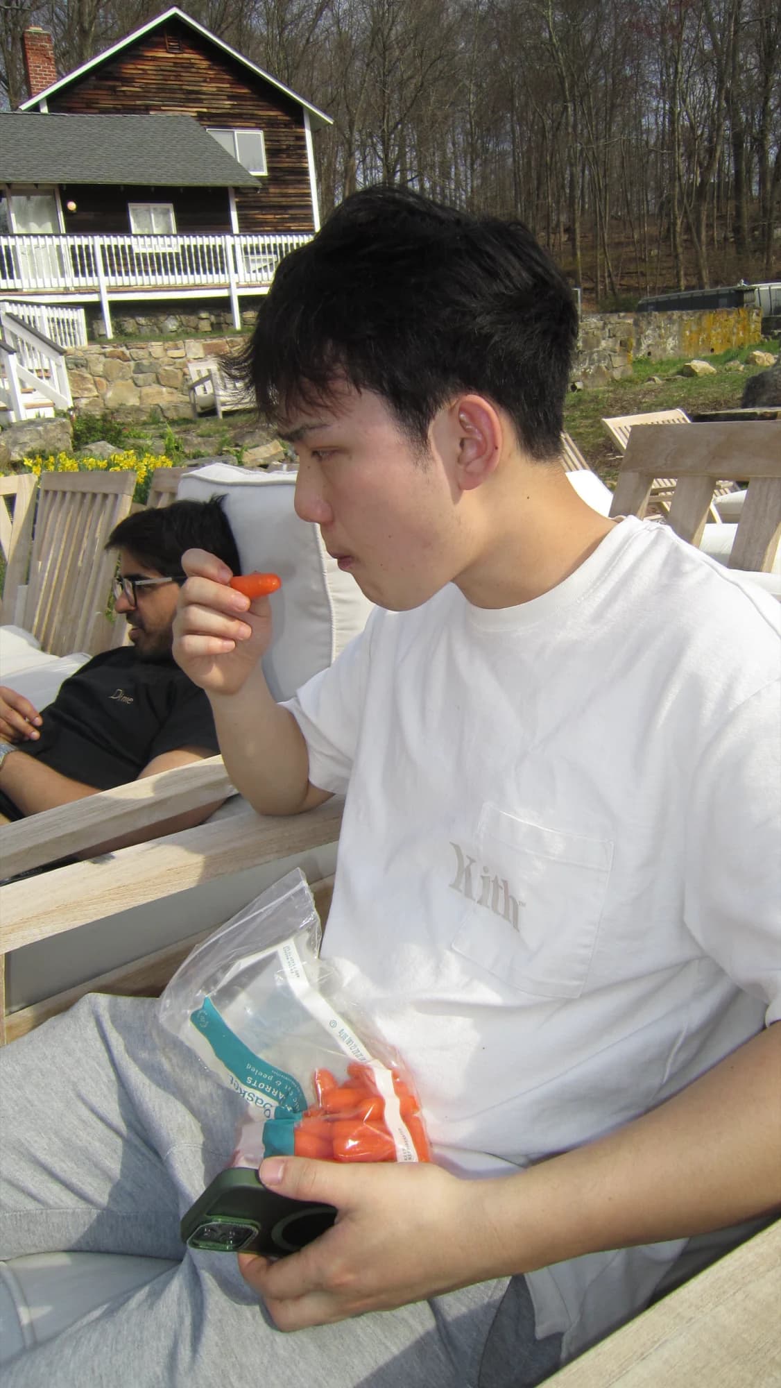 A member eating cherry tomatoes out of a bag on the deck